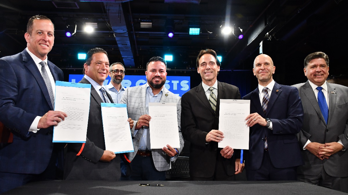 State Senator Steve Stadelman stands with State Senator Michael Hastings, State Senator Omar Aquino, State Representative Bob Morgan, State Representative Bob Rita and Illinois Governor JB Pritzker at the signing of four bills