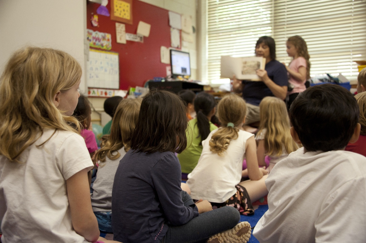 Teacher in school reading to children